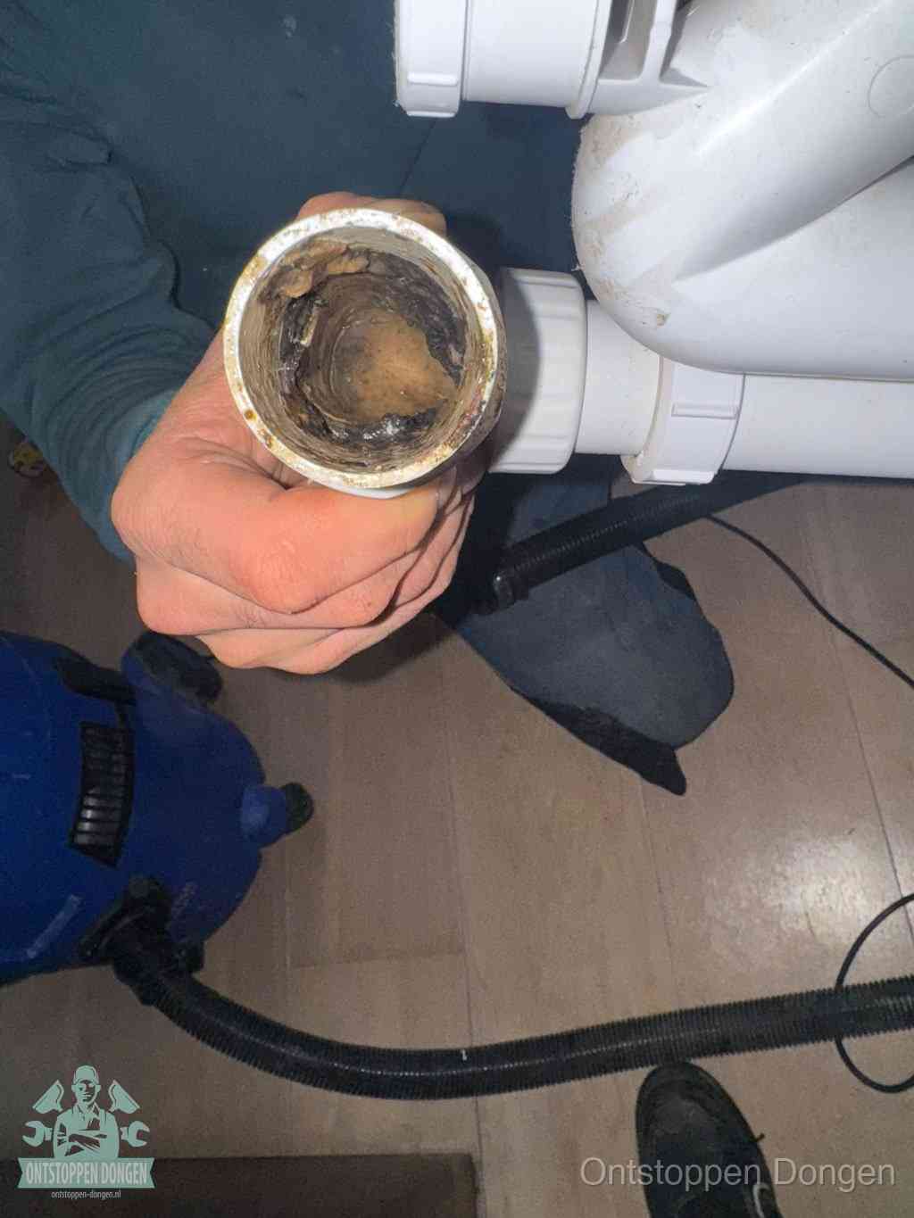 Een losgekoppeld afvoerbuisstuk dat van binnen volledig is dichtgeslibd, het gevolg van een verstopping te lang laten zitten in Dongen