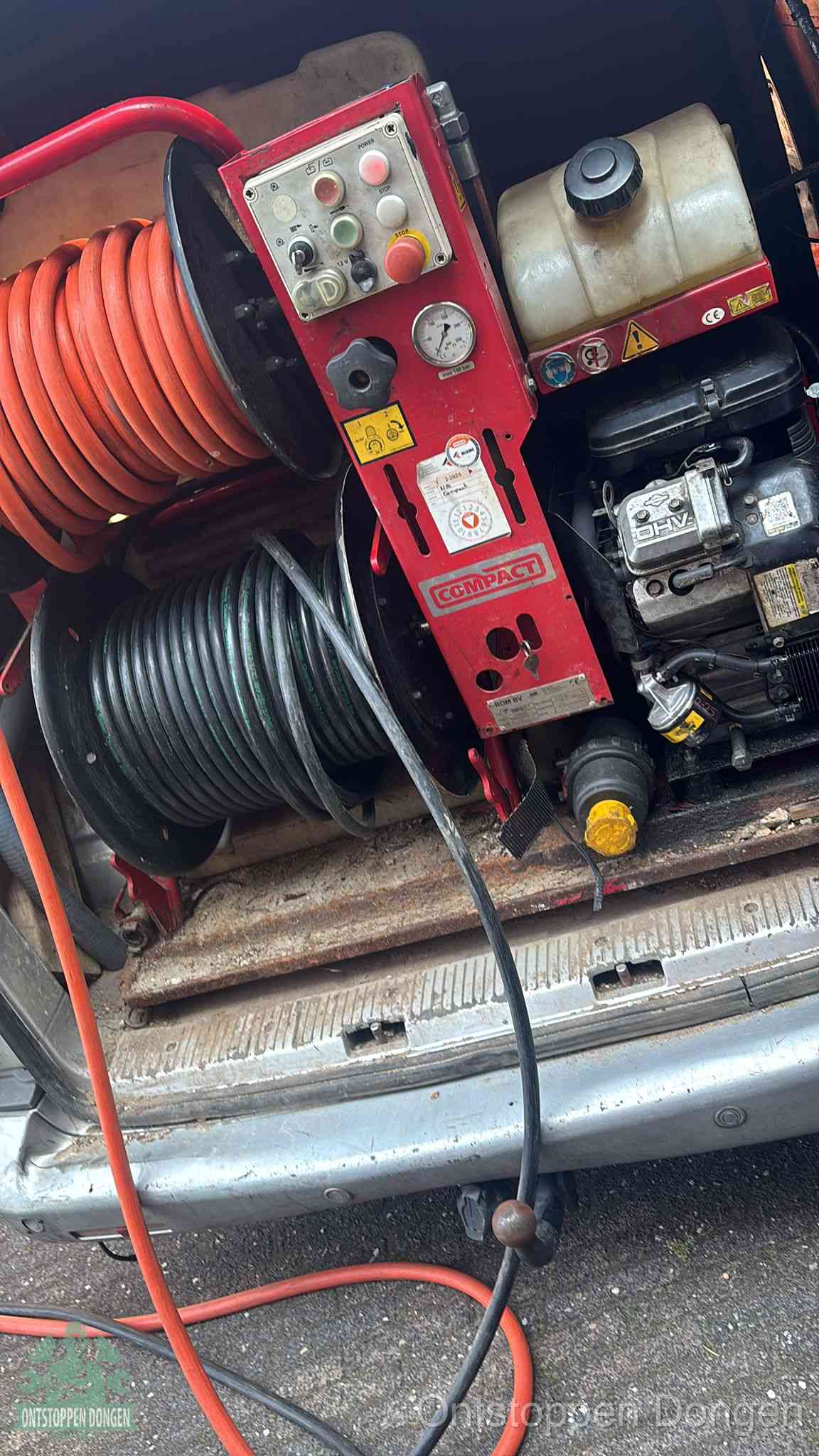 Een rood hogedruk-rioolreinigingstoestel in de laadbak van de bedrijfsbus, apparatuur voor een hardnekkige afvoerverstopping in Dongen