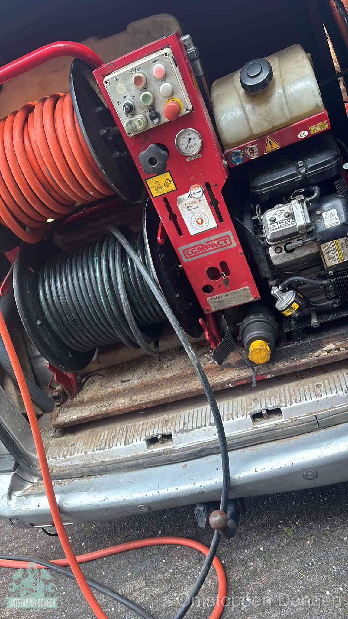 Een rood hogedruk-rioolreinigingstoestel met slangen in de laadbak van de bedrijfsbus, apparatuur voor een hardnekkige wc-verstopping in Dongen