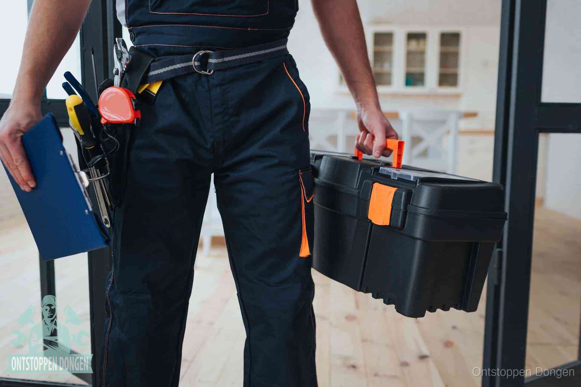 Een monteur met gereedschapsriem en klembord in een keuken, klaar om een transparante prijs voor het gootsteen ontstoppen in Dongen te geven