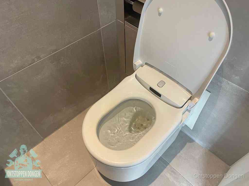 Een toiletpot vol troebel water met drijvend papier en restanten, de meest voorkomende oorzaak van een verstopte wc in Dongen