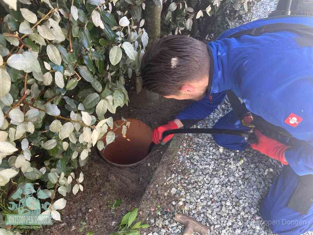 Monteur reinigt een rioolput met een slang, periodieke rioolreiniging in Dongen