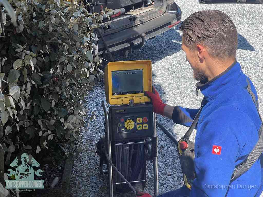 Monteur bedient een rioolinspectiecamera met monitor voor rioolinspectie in Dongen