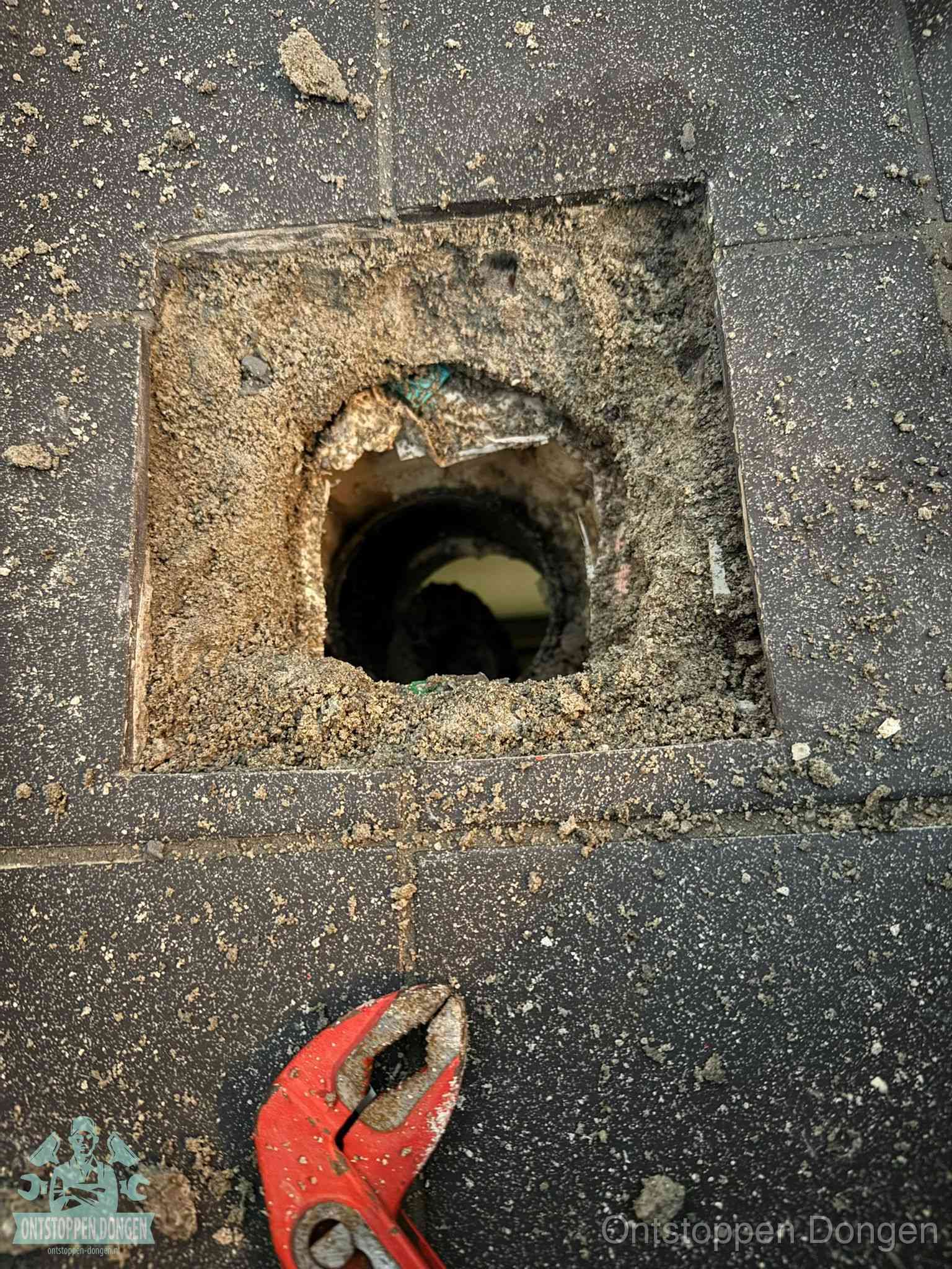 Geopend rioolputje op de erfgrens dat laat zien wie eigenaar is van de riolering in Dongen