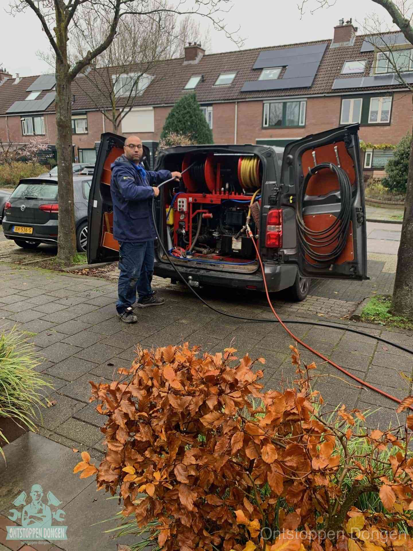 Monteur met rioolreinigingsbus levert rioolservice in de wijk in Dongen