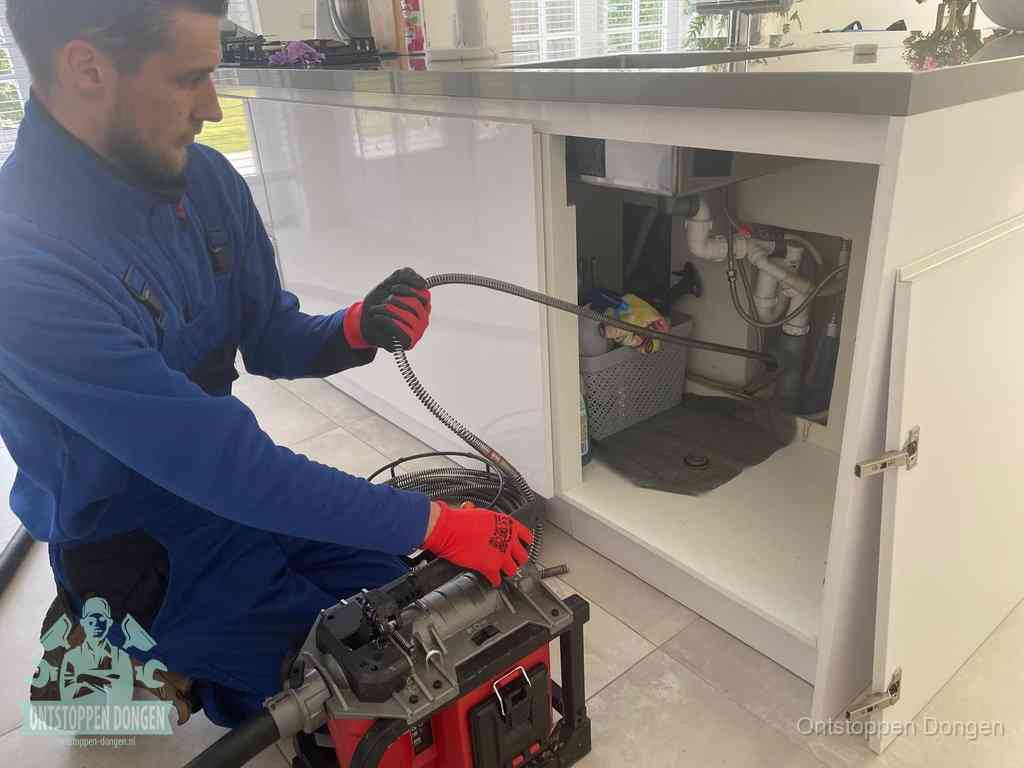 Een monteur reinigt de keukenafvoer grondig met een veermachine om terugkerende gootsteenverstoppingen te voorkomen in Dongen