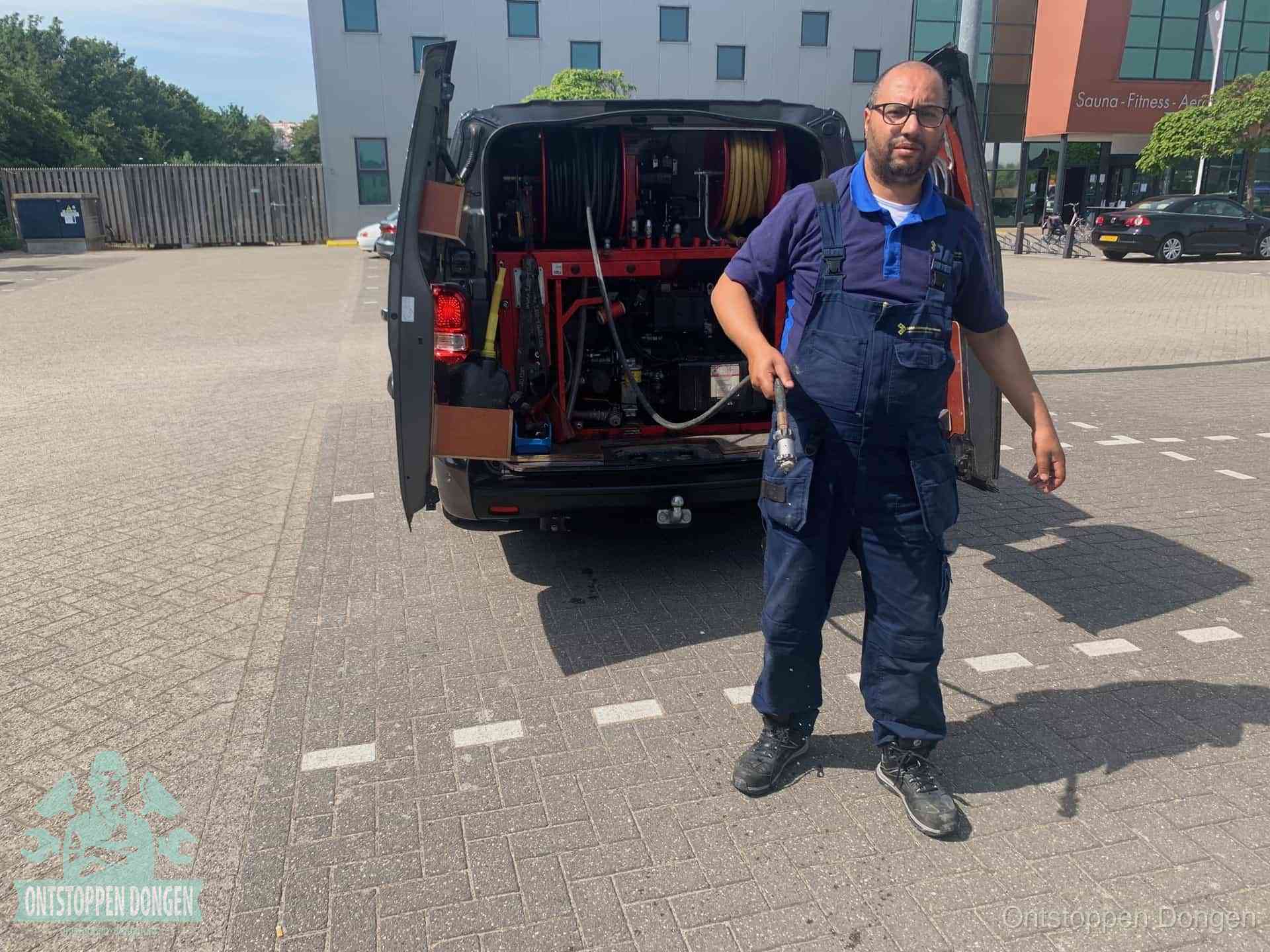 Een monteur bij zijn bestelbus met een hogedruk- en rioolreinigingsunit, klaar om de oorzaak van terugkerende wc-verstoppingen aan te pakken in Dongen