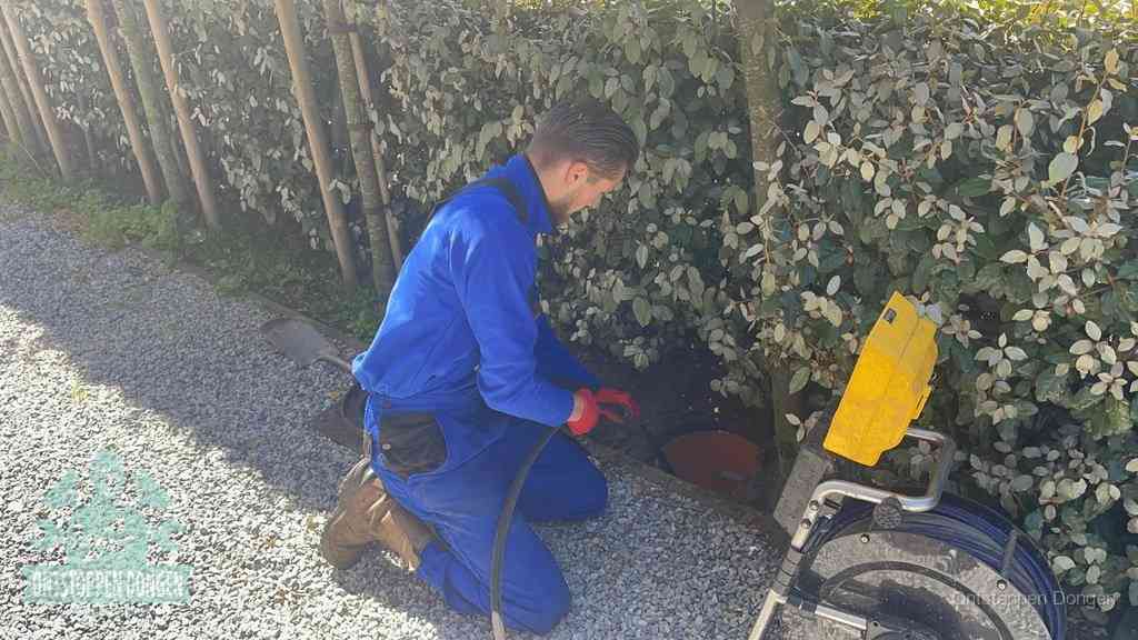 Monteur aan het werk bij een rioolput, de werkwijze voor riool ontstoppen in Dongen